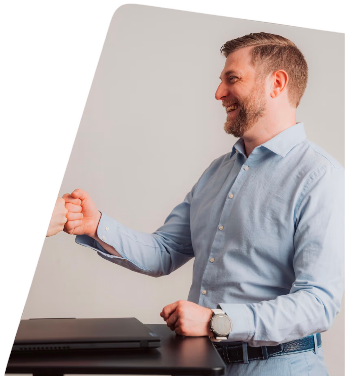 Stephan Trippl steht seitlich und streckt die Hand aus in die Richtung einer nicht sichtbaren Person